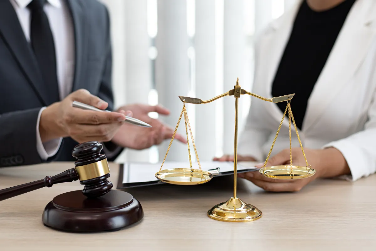 Civil lawyers in Bangalore reviewing case files beside gavel and golden balance scales.

